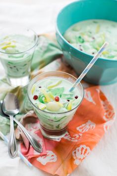 two bowls filled with food sitting on top of a white table covered in napkins