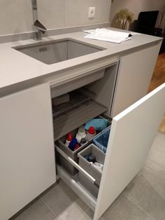 a kitchen sink with an open drawer underneath it