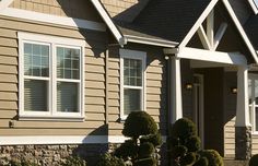 a row of houses with bushes and shrubs in front of the house on a sunny day