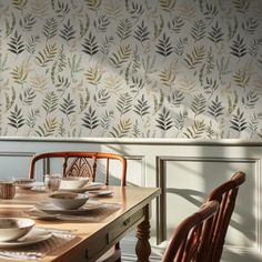 a dining room table with plates and bowls on it, next to a wallpaper