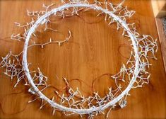 a wreath made out of branches on top of a wooden table