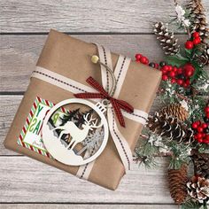 a present wrapped in brown paper with reindeer ornament on it and pine cones