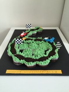 a birthday cake made to look like a race track with green frosting and black icing