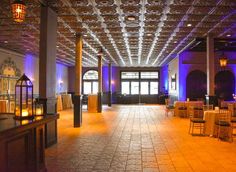 an empty ballroom with tables and chairs set up for a formal function at night time