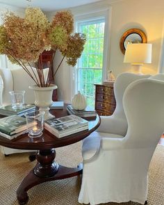 a living room filled with furniture and flowers in vases on top of a table