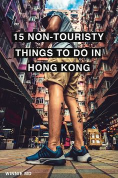 a man standing in front of tall buildings with the words 15 non - touristy things to do in hong kong