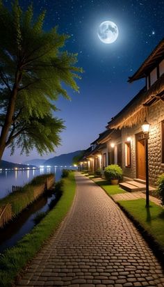 a cobblestone path leading to a house at night with the moon in the sky