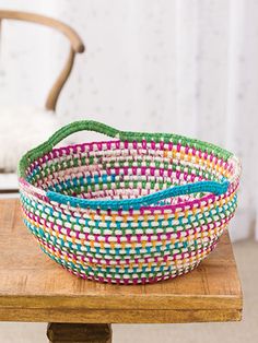 a colorful basket sitting on top of a wooden table