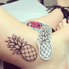 a woman with a tattoo on her leg has a pineapple sticker on her thigh