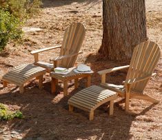 three wooden chairs sitting next to a tree