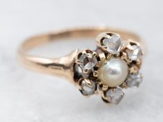 This antique halo ring is sweet and truly stunning! In the center is a lovely pearl! accented by sweet rose-cut diamonds. The combination of the stones and gold with the classic Victorian elements make this a unique and cool ring!Metal: 14K Antique Rose GoldGem: PearlGem Measurements: 3.5 mm, RoundAccents: 6 Rose-Cut DiamondsRing Size: 3.50Marks: “14K” Stamped on the inside band Victorian Wedding Ring With Rose Cut Diamonds, Luxury Victorian Style Diamond Ring With Rose Cut, Luxury Victorian Style Rose Cut Diamond Ring, Victorian Yellow Gold Pearl Ring With Rose Cut Diamonds, Victorian 14k Gold Diamond Ring With Rose Cut Diamonds, Pearl Halo Ring, Victorian Diamond Ring, Victorian Engagement Rings, Pearl Birthstone