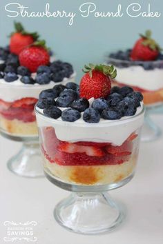 a layered cake with strawberries and blueberries on top