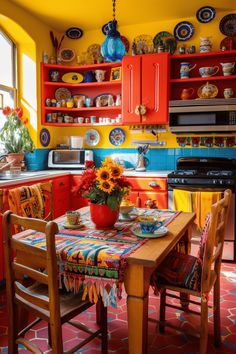 a kitchen with red cabinets, yellow walls and sunflowers on the dining table