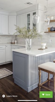 a kitchen with white cabinets and an island in the middle, surrounded by wooden floors