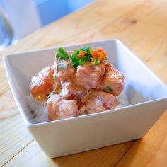 a white bowl filled with food on top of a wooden table