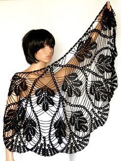 a mannequin wearing a black lacy shawl with flowers on it's back