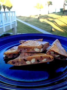 three pieces of food sitting on top of a blue plate in front of a house