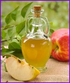 apple cider next to an apple on a table