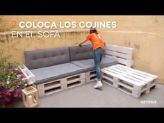 a woman sitting on top of a couch made out of pallets