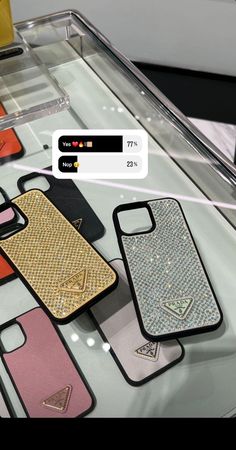 several cell phones are on display in a case with different colors and designs, along with an embellishment from the company's logo