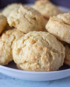 a white bowl filled with biscuits on top of a blue tablecloth covered countertop