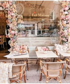 an outdoor cafe with tables and chairs covered in flowers