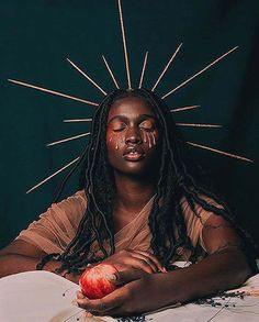 a woman with long dreadlocks holding an apple