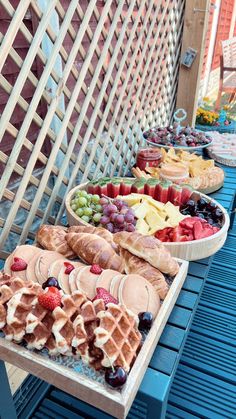 several different types of waffles are lined up on a blue picnic table outside