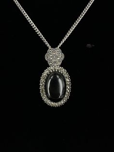 Vintage Sterling Silver Large Oval Black Onyx Marcasite Pendant Necklace 18.5"  Item here is a vintage sterling silver large oval black onyx marcasite pendant necklace. This pendant is marked sterling and hangs on a silver cable chain. The chain closes with a spring ring. Super beautiful large black onyx surrounded by sparkly marcasites. Condition: Good; item is pre-owned and may have some signs of light use and age related wear. Please look closely at the pictures provided as they are an extension of our written description. Measurements: Length: 18.5 in Width: 2.5 mm Pendant: 1.75 in x ⅞ in Weight: 18g 8652F Silver Oval Onyx Necklace, Silver Onyx Oval Necklace, Oval Marcasite Jewelry For Formal Occasions, Formal Oval Marcasite Jewelry, Silver Onyx Oval Pendant Necklace, Spring Rings, Cable Chain, Black Onyx, Vintage Sterling Silver