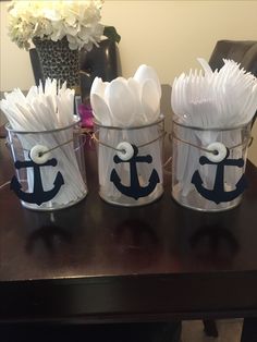 three buckets filled with white paper flowers and an anchor on the front one is holding tissue