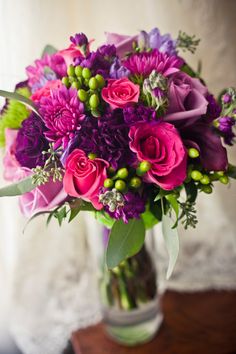 a vase filled with purple flowers on top of a table