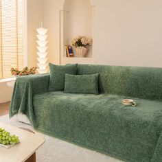 a living room filled with furniture covered in green blankets