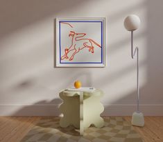 a painting hangs on the wall next to a table with an orange and blue design