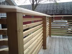 a wooden deck with railings and wood slats