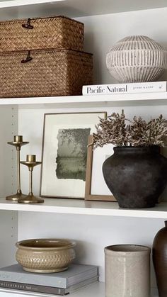 the shelves are filled with vases, pictures and other decorative items such as baskets