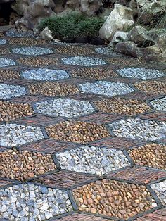 a cobblestone walkway with rocks and grass