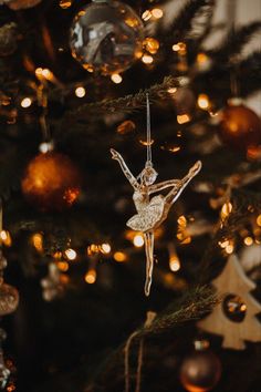 an ornament hanging from the tree in front of a christmas tree with lights