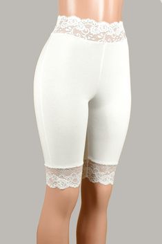 These soft and comfortable ivory/off-white high-waisted shorts have a stretch lace waistband and matching lace around the leg. Wear them under skirts, dresses, or shorts for extra leg coverage. White Lace Bottoms With Elastic Waistband, Lace Daywear Shorts, White Fitted Knee-length Shorts, White Stretch Bottoms With Contrast Lace, Lace Trim Shorts For Daywear, Lace Trim Short Bottoms For Daywear, White Fitted Pajama Shorts, Lace Loungewear Shorts, Fitted Lace Trim Pajama Shorts