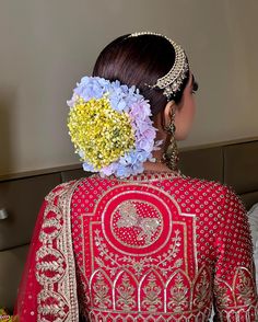 the back of a woman's head wearing a red and gold bridal gown