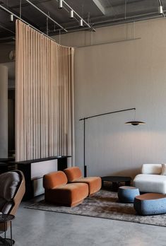 a living room filled with furniture and a large window covered in draping on the wall