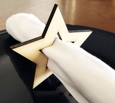 a napkin holder with a gold star on it sitting on top of a black plate