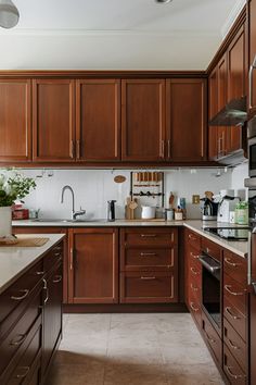 a kitchen filled with lots of wooden cabinets and counter top space next to a sink