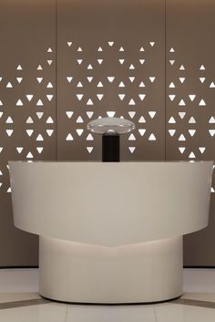 a white reception table sitting in front of a wall with cut out shapes on it