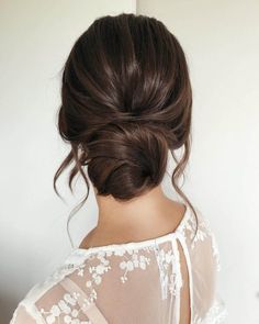 the back of a woman's head, with her hair in a low bun