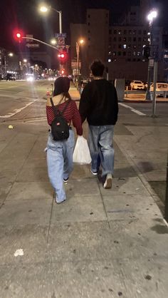 two people walking down the street at night