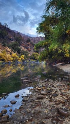 the river is surrounded by rocks and trees