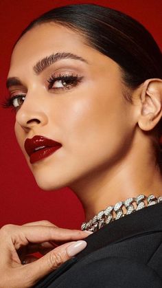 a woman with red lipstick and jewels on her neck