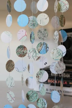 a close up of a mobile made out of different types of paper circles hanging from the ceiling