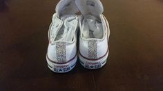 a pair of white tennis shoes sitting on top of a wooden floor