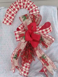 a red and white christmas wreath on top of a blue blanket with ribbon around it